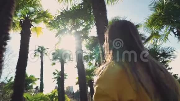 可爱的女孩拍棕榈树的照片然后离开视频的预览图