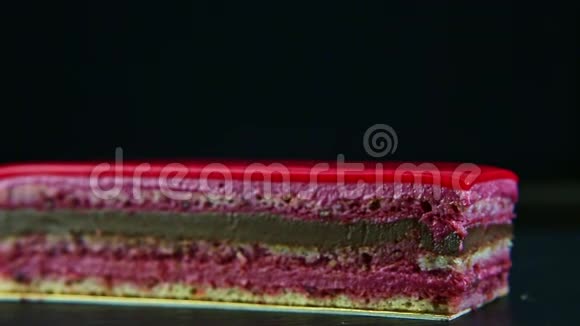 粉色釉面分层巧克力蛋糕和浆果馅的特写全景视频的预览图