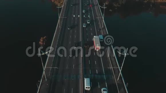 平滑的无人机摄像头与过往的汽车在桥上俯瞰城市视频的预览图