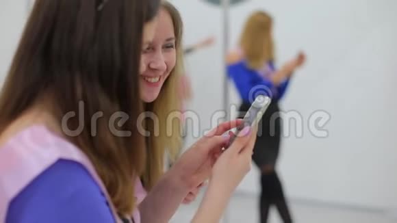 参加派对的女孩在智能手机上观看照片视频的预览图