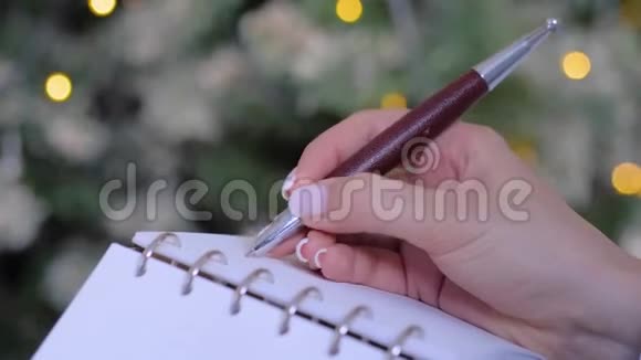 在老式笔记本上写清单的女人圣诞节概念视频的预览图