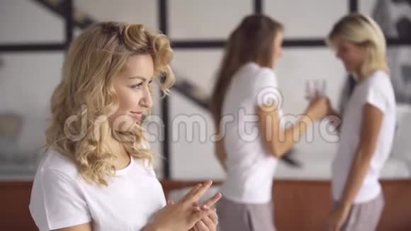 可爱的女人在前景中展示着金色的戒指而她的女朋友在背景中喝酒妇女视频的预览图