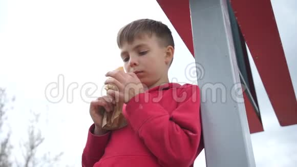 站在柱子上吃面包的男孩视频的预览图
