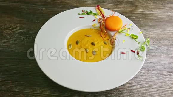 用白色塑料勺子把南瓜奶油汤放在碗里视频的预览图