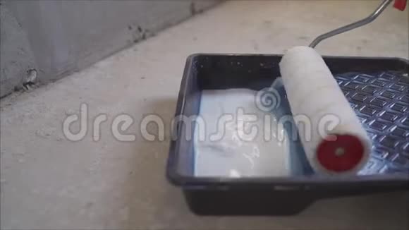 浴室里的滚筒用腻子准备在墙上涂油漆滚筒的人浴缸里的白色腻子视频的预览图