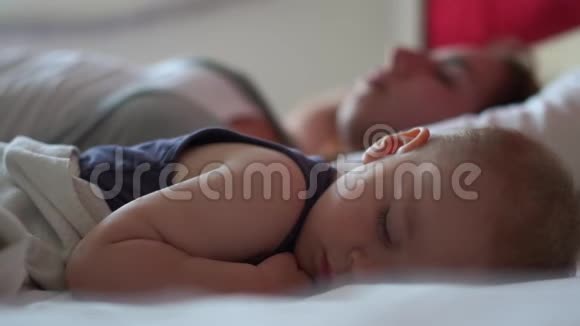 白天女人和她的小儿子在一张大床上甜蜜地睡在一起视频的预览图
