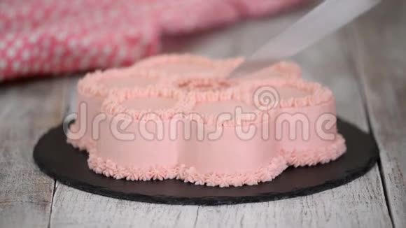 女人她的手用粉红色奶油做蛋糕形状像一朵花视频的预览图