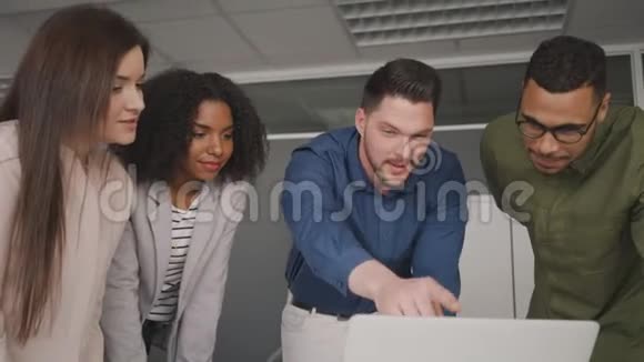 专业自信的年轻商人向他的同事展示笔记本电脑上的在线项目和营销策略视频的预览图