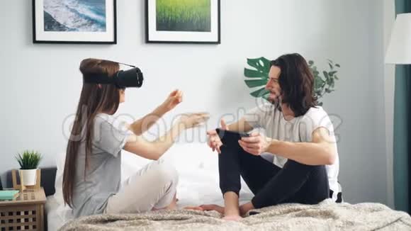 年轻女性使用vr眼镜移动双手男友触摸平板电脑视频的预览图