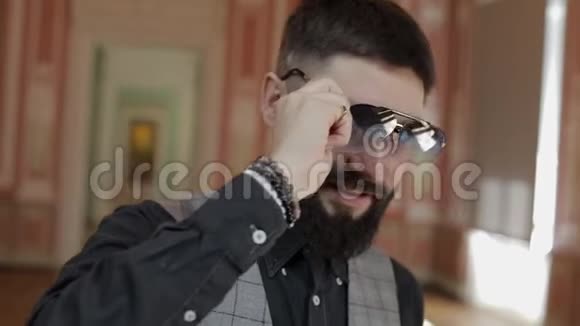 面对迷人的时尚胡须男人摘下太阳镜帅哥在笑视频的预览图