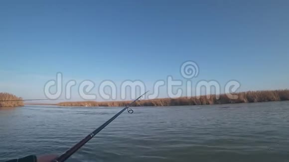 一个渔夫在一条河上的一条小船上钓到了一条食肉鱼第一人称视角视频的预览图