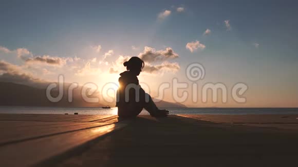 4k女孩在日落时分在海边小腿做腿部按摩动作缓慢视频的预览图