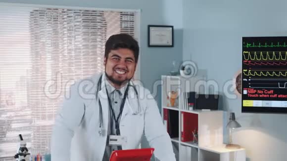 混合种族微笑医生穿着实验室外套在跑步机上行走的特写镜头视频的预览图
