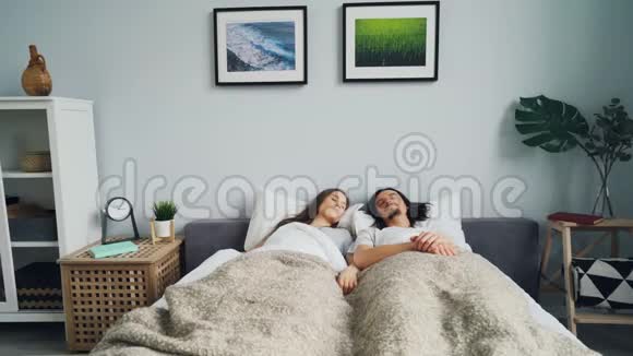 睡不着的女孩和男人在家里的床上醒来起床离开卧室视频的预览图