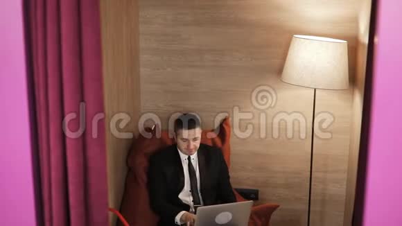 疲惫的成熟男人在办公室里坐在豆袋椅上工作视频的预览图