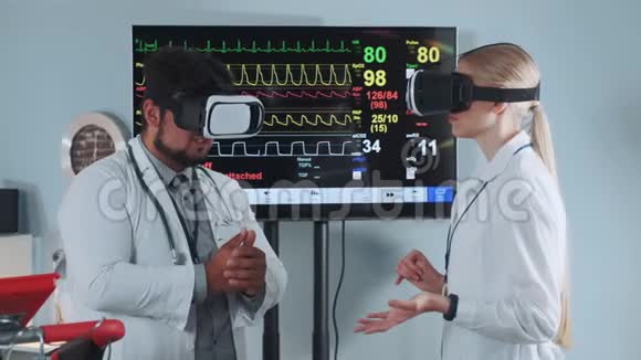 戴着VR眼镜的混合种族医生在现代体育实验室讨论一些事情视频的预览图