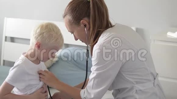 医生用听诊器听诊所里的一个男孩说话视频的预览图