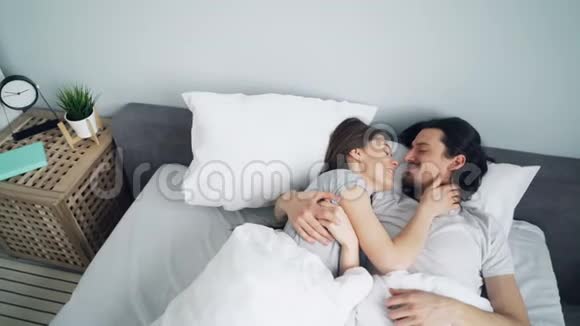 高角度视角的可爱情侣拥抱接吻然后在家睡觉视频的预览图