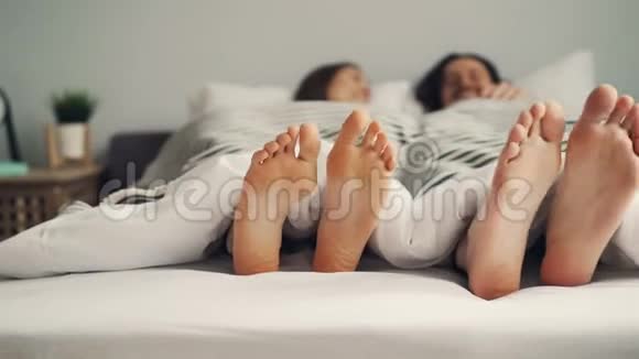 人类的双脚在床上以有趣的节奏移动夫妇在卧室里玩得很开心视频的预览图