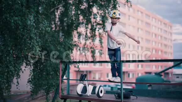 站在陀螺滑板车附近的栏杆上跳舞的男孩视频的预览图