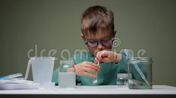 学龄前儿童做实验眼镜中的年轻科学家混合了地衣进行实验家庭实验室背景视频的预览图