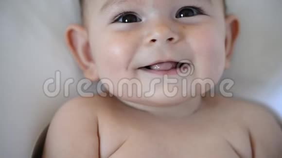 带着棕色大眼睛的可爱快乐宝宝的微笑肖像欢乐的童年视频的预览图