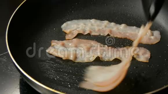 薄的培根片用葵花籽油在热锅里炒不粘涂层男士厨师早餐烹饪视频的预览图