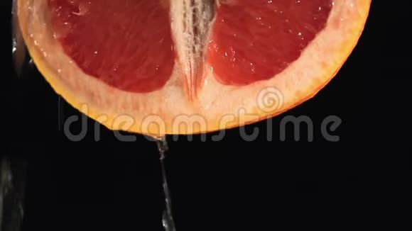 一半的葡萄柚被隔离在黑色背景上视频的预览图