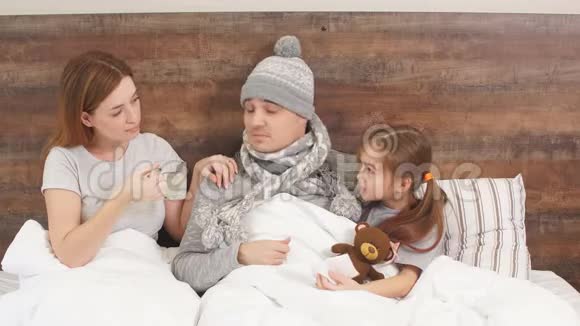患有高温的病人躺在床上有着细心的孩子和妻子视频的预览图