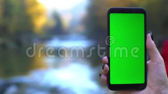 大自然中的智能手机4k技术概念带绿色屏幕的手机在瀑布上跟踪哑光视频的预览图