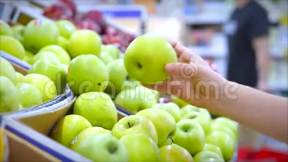 女人们在超市里买食物水果苹果西红柿桔子女孩选择产品视频的预览图