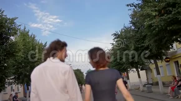 一对年轻夫妇沿着欧洲城镇的步行街散步视频的预览图