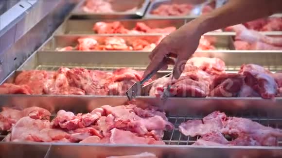 男人买肉看鸡上的肉用钳子在市场上超市里挑肉视频的预览图