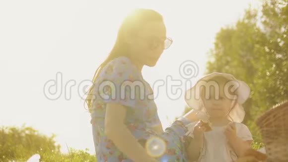 年轻女子和她的小女婴在一个美丽的夏日野餐视频的预览图