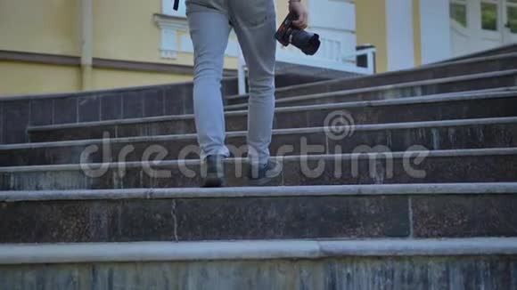 游客腿的后视图与相机攀登的台阶的历史建筑视频的预览图