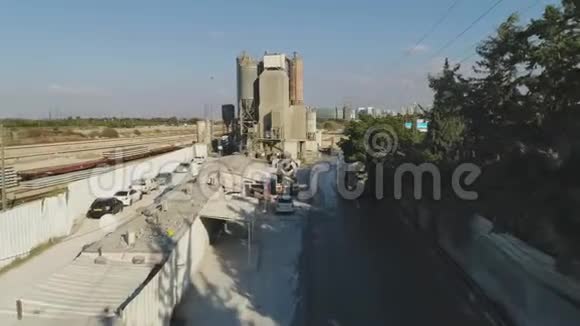 在水泥厂上空的无人机卡车装载和浇筑沙子建筑工业用地视频的预览图