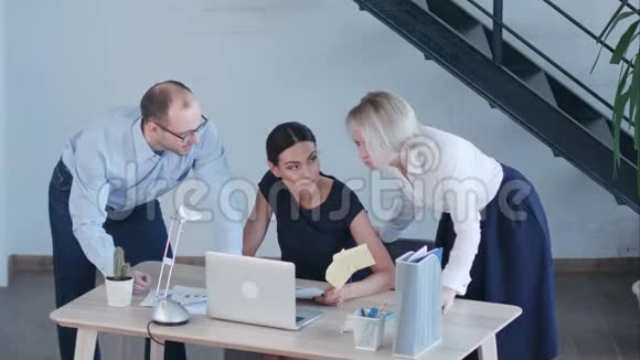 漂亮的商务人士在办公室工作时使用笔记本电脑学习文件交谈和微笑视频的预览图