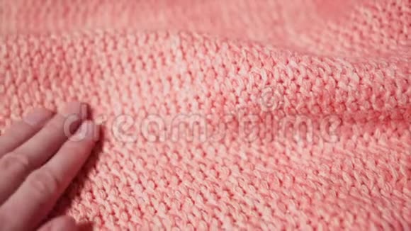 针织布柔软的粉红色珊瑚色女人手触摸手工时尚的美利奴面料检查织物视频的预览图