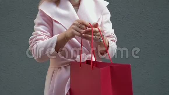 这位女士打开一个红色的纸袋从里面拿出一份礼物视频的预览图