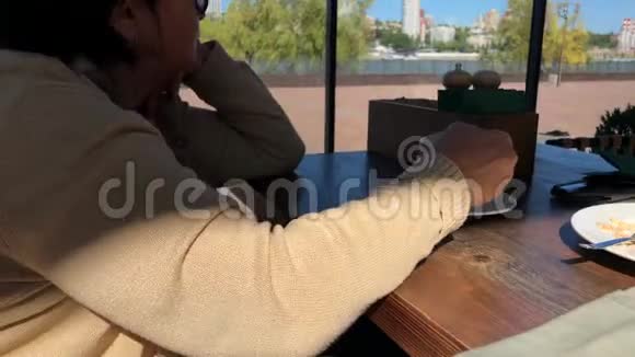 一个年轻的女孩和一个年老的女人坐在咖啡馆里视频的预览图