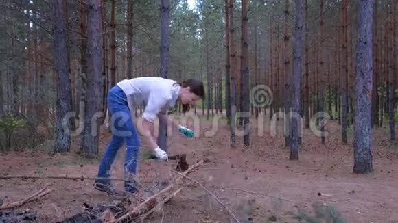 森林露营的年轻女子用斧子砍树枝作为柴火视频的预览图