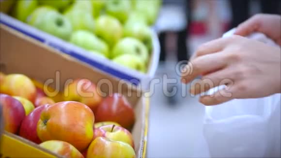 女人在超市里买食物水果苹果桔子女孩在超市里挑选食物蔬菜水果视频的预览图