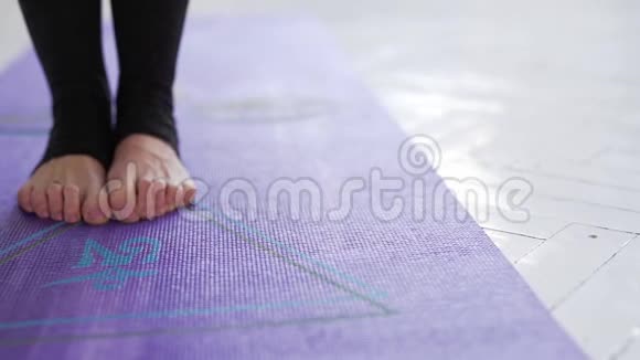 在室内的紫罗兰瑜伽或健身垫上特写女性腿做瑜伽姿势视频的预览图