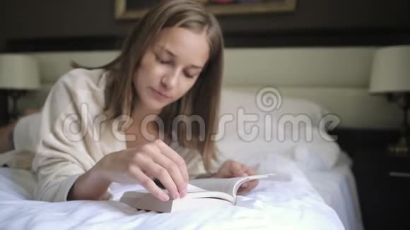 女人在翻书页躺在床上看书视频的预览图