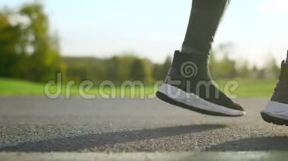 男人的脚在路上跳舞活跃的运动员在公园里跳腿视频的预览图
