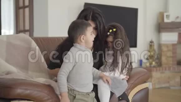 漂亮的中东女人坐在教练上带着两个孩子快乐的母亲度过周末视频的预览图