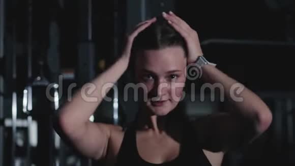 年轻的运动的女孩在努力锻炼后从额头上擦汗视频的预览图