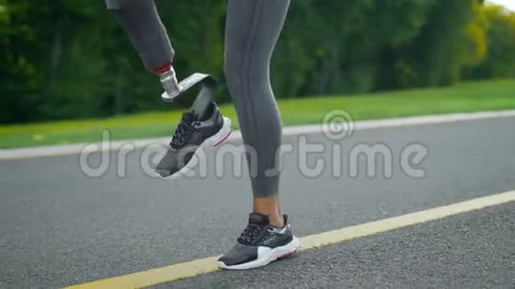 残疾妇女在锻炼时做高膝关节敲击公园女孩腿训练视频的预览图
