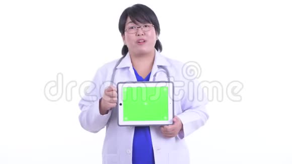 快乐超重的亚洲女医生在讲数字平板电脑视频的预览图