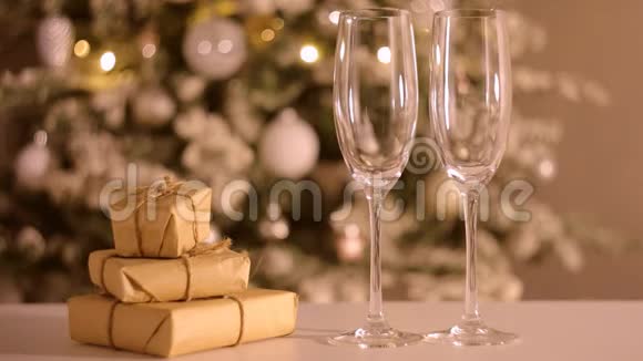 香槟酒正倒入礼品盒附近的两个玻璃杯中圣诞节和新年视频的预览图